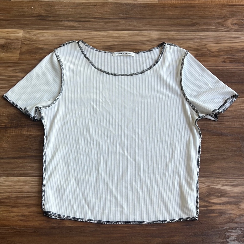 Caution to the wind white t shirt with black inside out stitching